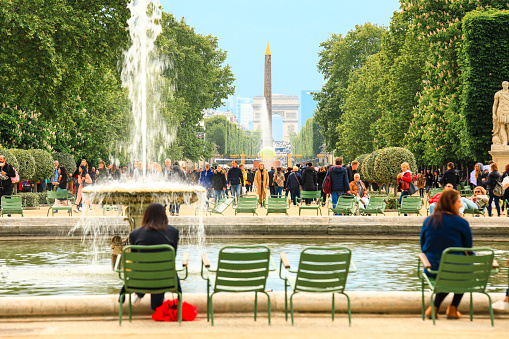 Paris, France - June 17, 2019: Selective focus on Obelisk and triumphal arch with tourists enjoy the vacation at the Tuileries Garden in Paris