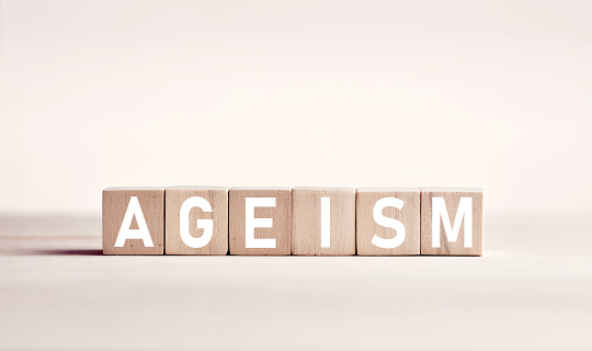 The word ageism on wooden blocks against white background. Age discrimination in business concept.
