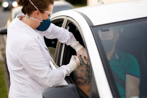 Drive Through covid-19 vaccination Female doctor applying injection. vacina stock pictures, royalty-free photos & images