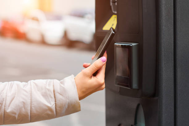 istock Woman using her mobile phone for payment for public parking by NFC. Contactles payment system with copy space. 1271757590