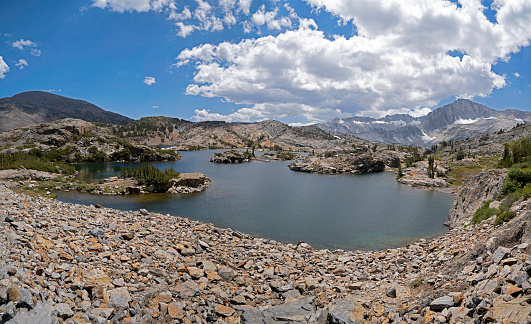 Part of the 20 Lakes region of Northern California, Shamrock Lake attracts hike-in campers.  Several tents are pitched to the right side, background, of the frame.