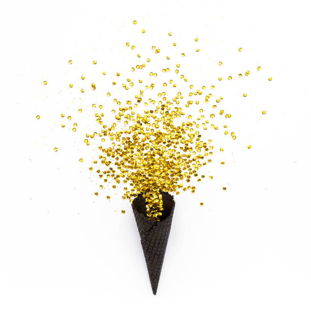 istock Black waffle cones with golden confetti tinsel isolated on white background. Flat lay, top view minimal festive concept 1271758925