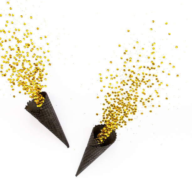 istock Black waffle cones with golden confetti tinsel isolated on white background. Flat lay, top view minimal festive concept 1271759022