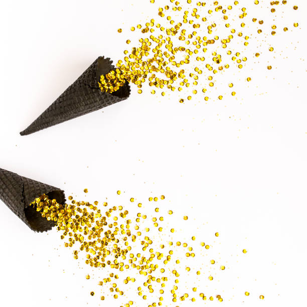 istock Black waffle cones with golden confetti tinsel isolated on white background. Flat lay, top view minimal festive concept 1271760076