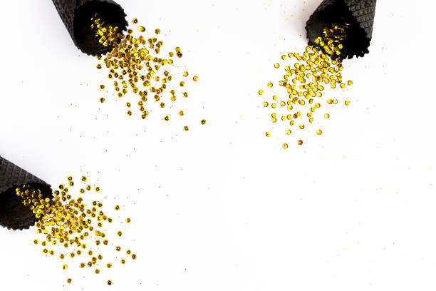istock Black waffle cones with golden confetti tinsel isolated on white background. Flat lay, top view minimal festive concept 1271760861