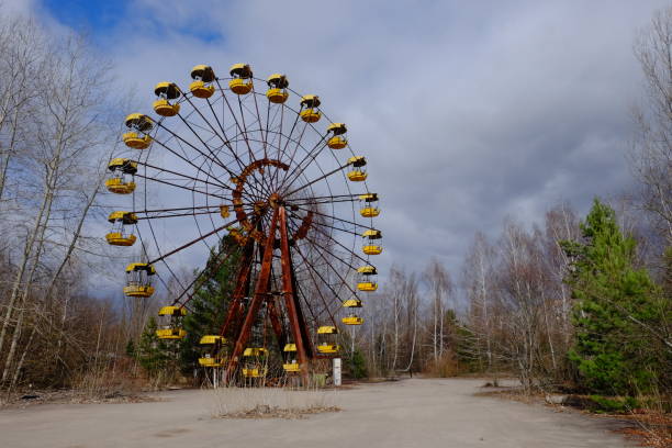 The famous Ferris wheel in an abandoned amusement park in Pripyat. Cloudy weather in the Chernobyl exclusion zone. The famous Ferris wheel in an abandoned amusement park in Pripyat. Cloudy weather in the Chernobyl exclusion zone. chornobyl photos stock pictures, royalty-free photos & images