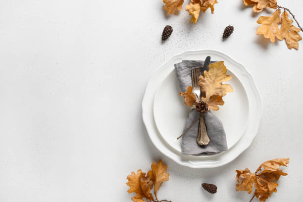 istock Fall table setting with autumn leaves and white plate on white table. Top view. Copy space. 1271761303