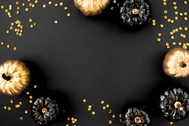istock Modern background with black and gold Halloween pumpkin with copy space for text. isolated on black background. Flat lay, top view 1271762491