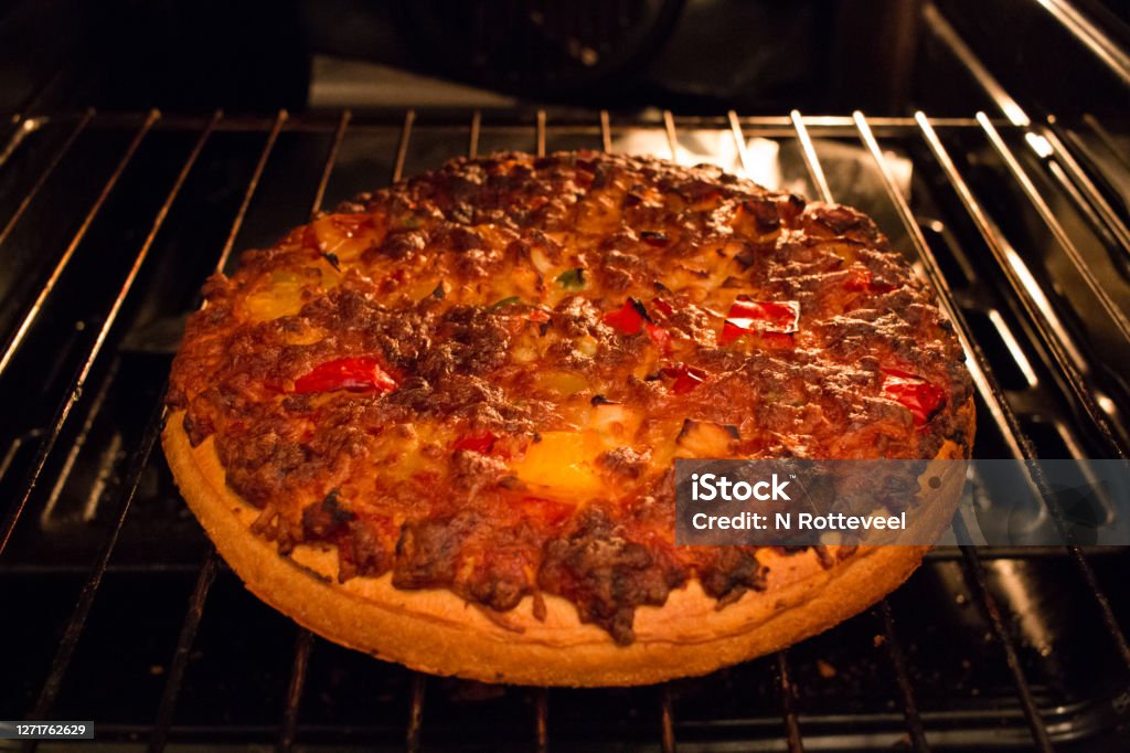 Tasty home made pizza just out of the hot oven. Fast food at home. A tasty home made pizza just out of the hot oven. Fast food at home. Oven Stock Photo