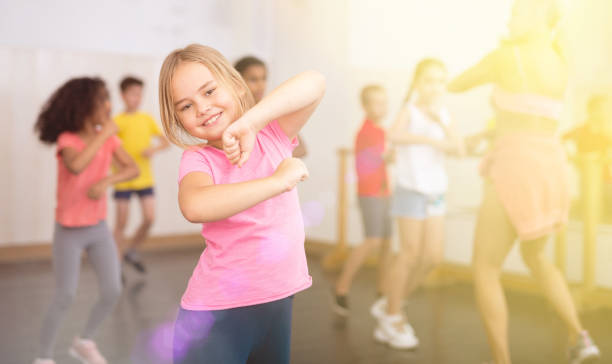 istock Smiling little girl training movements in children dance studio 1271762819