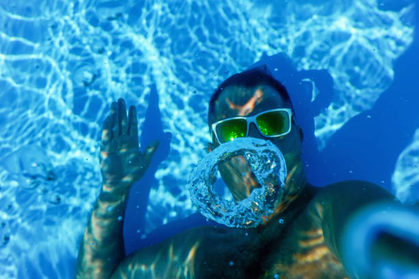 istock Pool Summer Party, Man Making Bubble Rings Underwater in Swimming Pool 1271765062