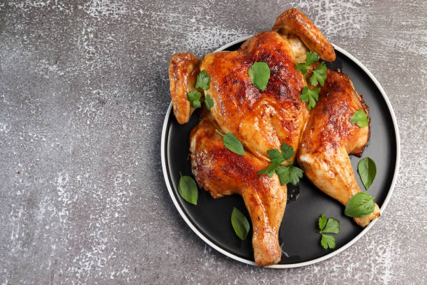 istock Baked whole chicken on a round plate on a dark background 1271766798