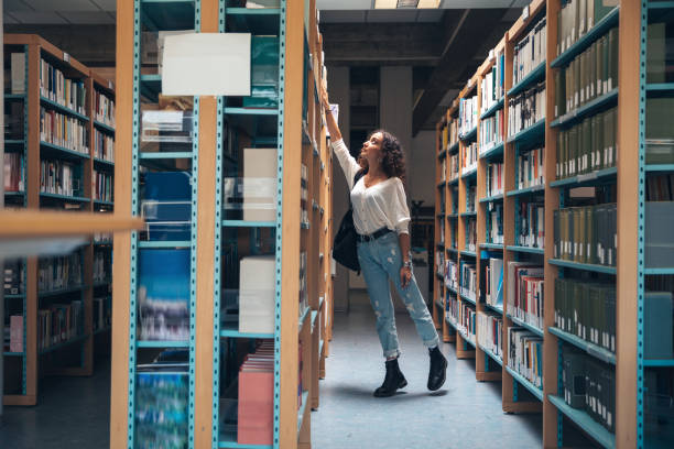 istock Young student choosing books on the bookshelf 1271770839
