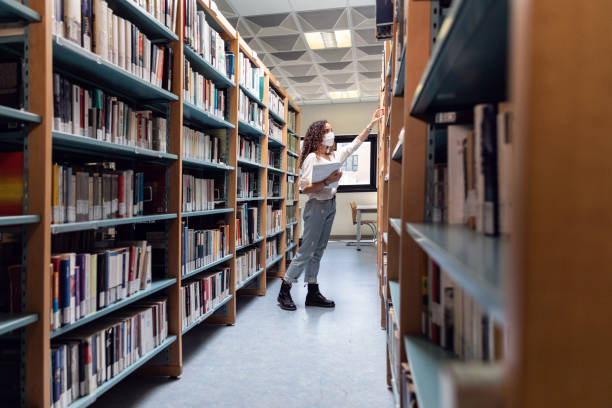 istock Student choosing books on the bookshelf 1271774063
