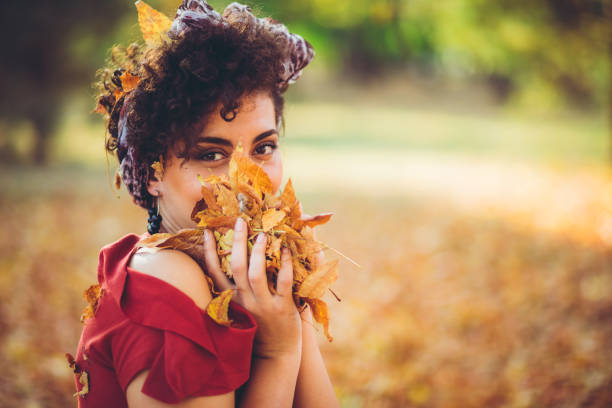 Young caucasian beautiful woman holding autumn leaves.