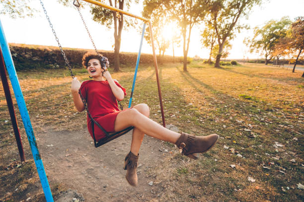 istock Young woman on a swing in a park 1271777939