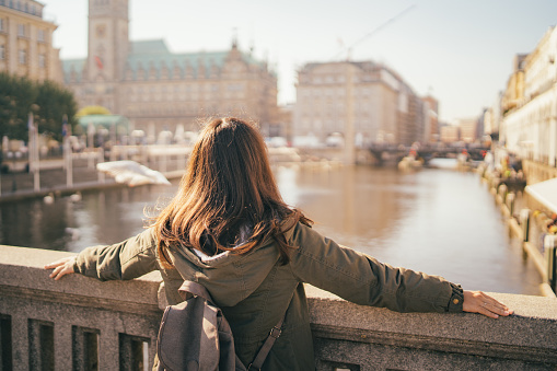 Young, woman, tourist, enjoying a view from the bridge, wearing a sunglasses. Jungfernstieg, Hamburg, Germany.