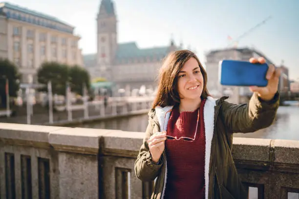 Young tourist woman is making selfies / vlogging in Hamburg city center.