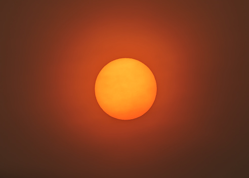 Smoke and ash particles creating eerie sun glow in San Francisco Bay Area.