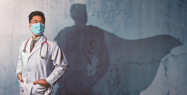Brave Doctors with his shadow of superhero on the wall. Concept of powerful man Brave Doctors with his shadow of superhero on the wall. Concept of powerful man heroes photos stock pictures, royalty-free photos & images