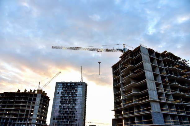 istock Tower crane in action on sunset sky background 1271782761
