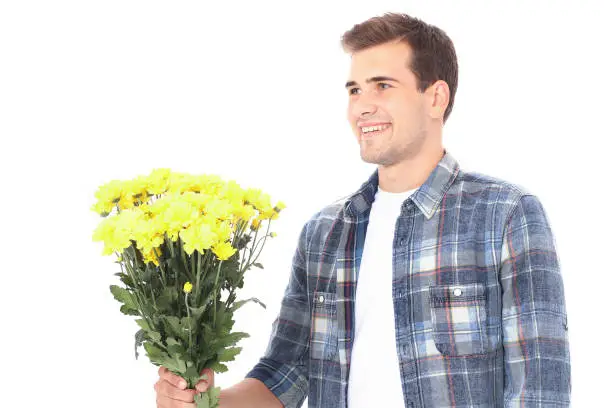Photo of Mothers day. Smiling handsome man with yellow bouquet of flowers isolated on white. Copy space and mock up