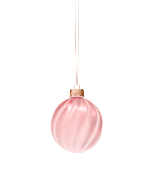 Pink twisted ribbed Christmas ball hanging on cord. Isolated on white background. Christmas decoration, festive atmosphere concept.