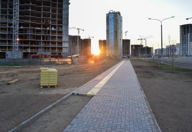 Laying paving slabs and borders at construction site. Process of installing paving bricks in the town pedestrian zone. Screeding the sand for install concrete blocks. Road works on pavement renovation colocación de losas de pavimentación y bordes en el sitio de construcción. proceso de instalación de pavimentos en la zona peatonal de la ciudad. atornillar la arena para instalar bloques de hormigón. obras viales sobre la renovación del pavimento