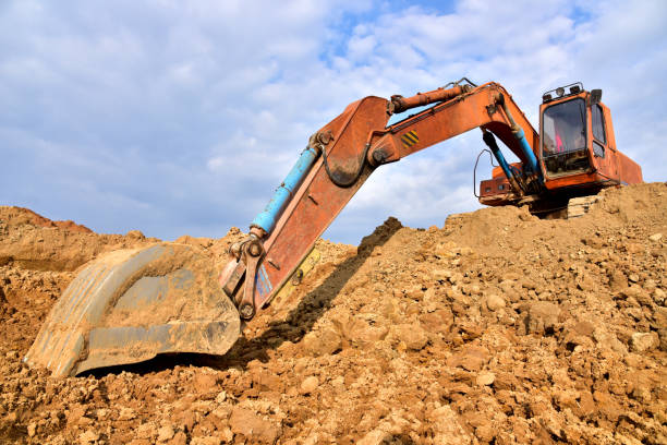 istock Excavator working on earthmoving at open pit mining. Backhoe digs gravel in quarry. Construction machinery for excavation, loading, lifting and hauling of cargo on job sites 1271789072