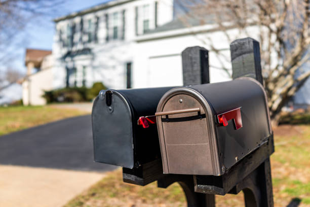 closeup of two modern black and brown metal red flag mailboxes at single family home in residential suburbs with nobody and house in background - house residential structure two objects building exterior imagens e fotografias de stock