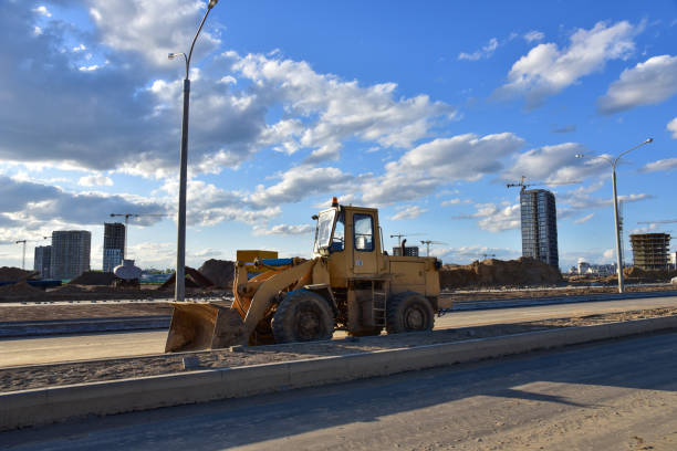 istock Front-end loader working at construction site on road work. Earth-moving heavy equipment and construction machinery. Laying asphalt, borders, slabs and bricks on highway 1271789238