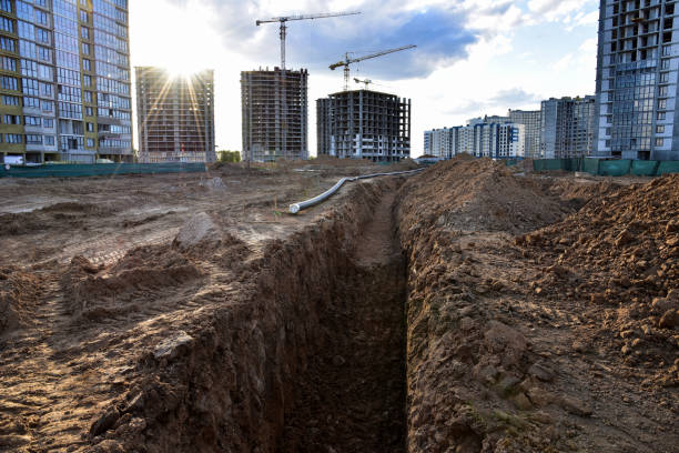 Trench for laying sewer pipes of the external sewage system at a construction site. Sanitary drainage system for a multi-story building. Civil infrastructure pipe, water lines and storm sewers trinchera para la colocación de tuberías de alcantarillado del sistema de alcantarillado externo en un sitio de construcción. sistema de drenaje sanitario para un edificio de varios pisos. tubería de infraestructura civil, líneas de agua y alcantarill