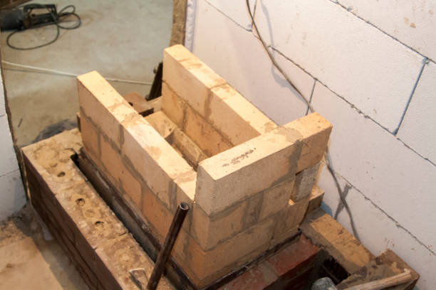 istock Sauna stove that is being built from fire resistant material in undeveloped interior laid out of foam blocks in country house under construction 1271794273