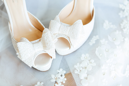 Luxury leather wedding shoes and veil, selective focus.