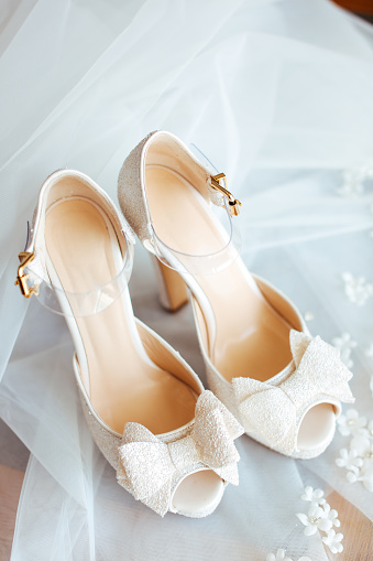 Luxury leather wedding shoes and veil, selective focus.