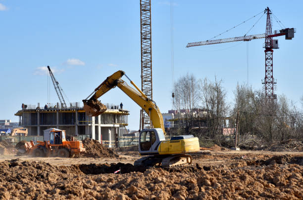 istock Excavator working at construction site on earthworks. Backhoe digging building foundation. Paving out sewer line. Construction machinery for excavating, loading, lifting and hauling of cargo 1271796001