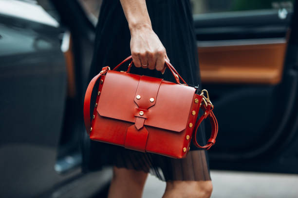 les femmes tiennent le sac à main près de la voiture de luxe - sac à main photos et images de collection