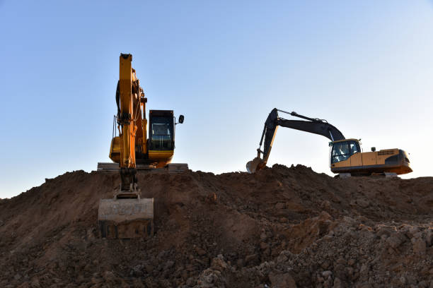 Yellow excavators during earthmoving at open pit on blue sky background. Construction machinery and earth-moving heavy equipment for excavation, loading, lifting and hauling of cargo on job sites excavadoras amarillas durante el movimiento de tierras a cielo abierto sobre el fondo del cielo azul. maquinaria de construcción y equipos pesados de movimiento de tierra para excavación, carga, elevación y acarreo de carga en lugares de trabajo
