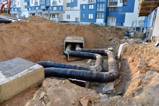 istock Laying heating pipes in a trench at construction site. Install underground storm systems of water main and sanitary sewer. Cold and hot water, heating and heating system of apartments in the house 1271799160
