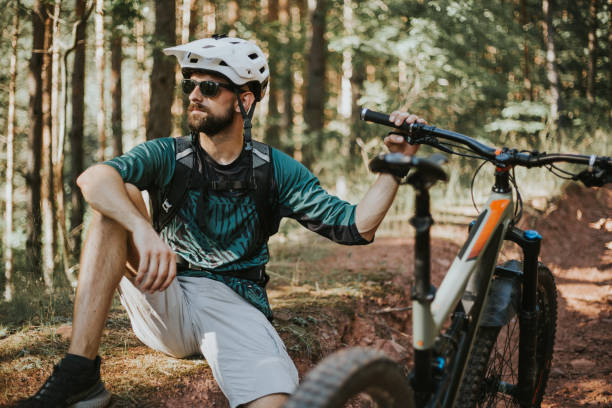istock Man is sitting in the woods and taking a break from riding a bicycle. 1271799343