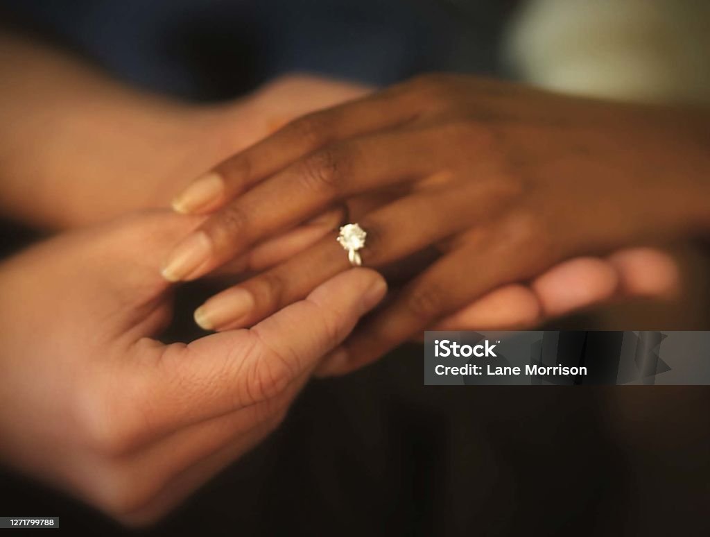 Interracial Hands Putting on Engagement Ring Close up photo of interracial couple hands putting on an engagement ring. Love, wedding, bridal, engagement, anniversary concept. White Man, Black Woman Wedding Stock Photo