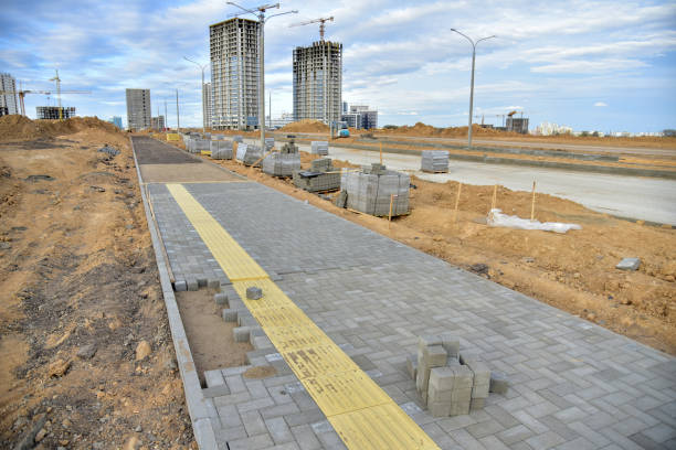 Laying paving slabs and borders at construction site. Process of installing paving bricks in the town pedestrian zone. Screeding the sand for install concrete blocks. Road works on pavement renovation