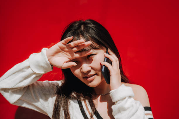 istock Asian young woman phoning, hand at forehead. 1271802286