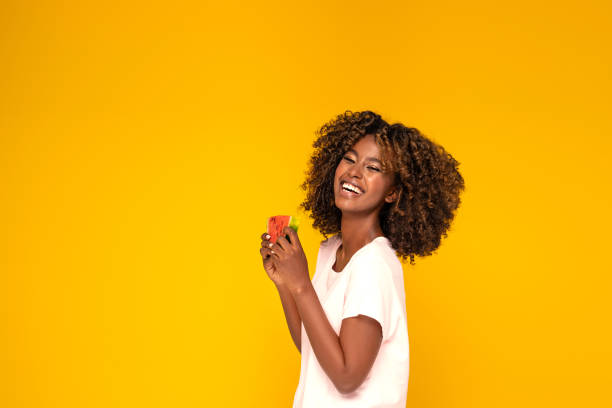 Afro girl eating watermelon .