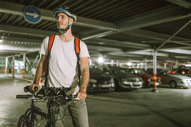 Pizza delivery man with bicycle in parkade