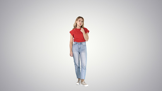 Full length shot. Unhappy and thoughtful young woman in casual on gradient background. Professional shot in 4K resolution. 006. You can use it e.g. in your commercial video, business, presentation, broadcast