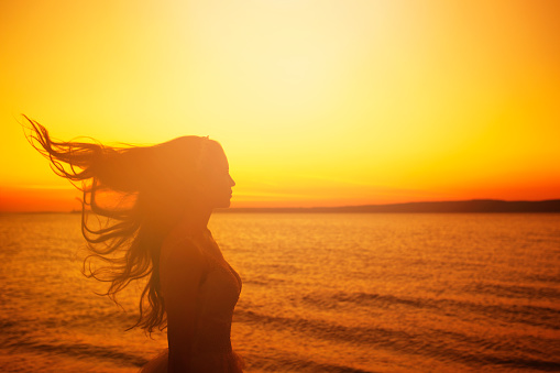 Young womanenjoys the freedom and fresh air at sunset