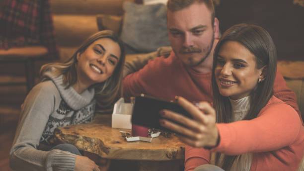 istock Three friends taking pictures with a smartphone 1271842429