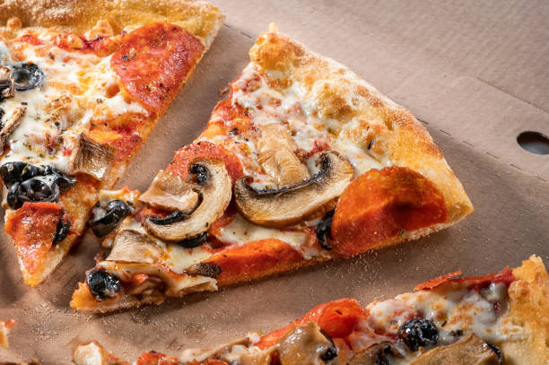 tranches de pizza aux champignons, olives noires, fromage et salami en gros plan - fast food italian culture studio shot macro photos et images de collection