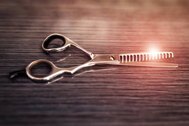 Hair thinning scissors on table in professional hairdressing salon. Selective focus, copy space